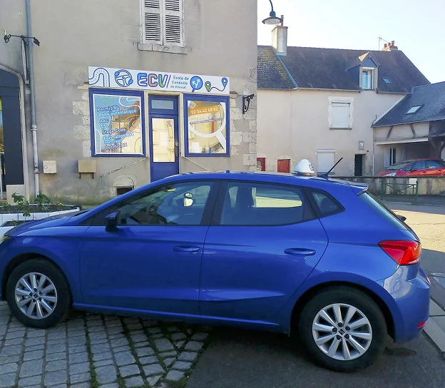 Une auto-école avec une voiture bleue garée devant, dans une ville française à Vineuil près de Blois dans le Loir-et-Cher 41