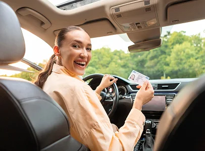Jeune femme souriante dans une voiture, tenant un permis de conduire à Vineuil près de Blois dans le Loir-et-Cher 41