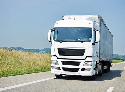 Camion blanc semi-remorque roulant sur une route de campagne ensoleillée à Vineuil près de Blois dans le Loir-et-Cher 41