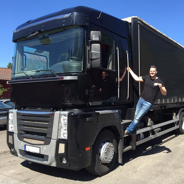 Homme souriant posant sur le marchepied d'un gros camion noir et gris à Vineuil près de Blois dans le Loir-et-Cher 41