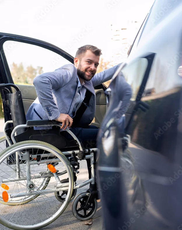 Homme souriant en fauteuil roulant, se préparant à entrer dans une voiture à Vineuil près de Blois dans le Loir-et-Cher 41