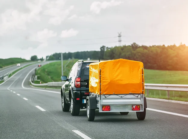 SUV noir avec petite remorque orange sur une autoroute verdoyante à Vineuil près de Blois dans le Loir-et-Cher 41